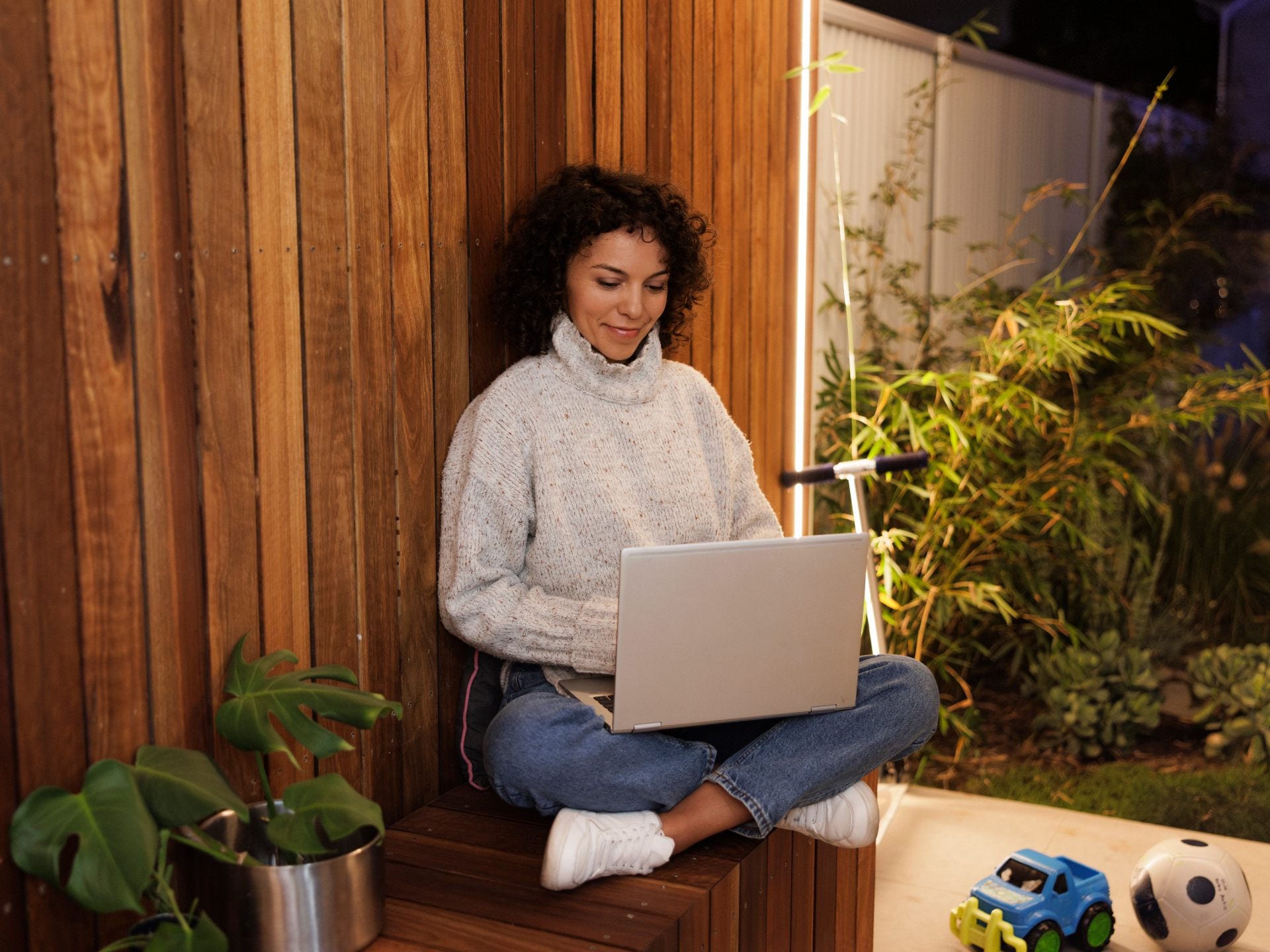 online student in a backyard with laptop