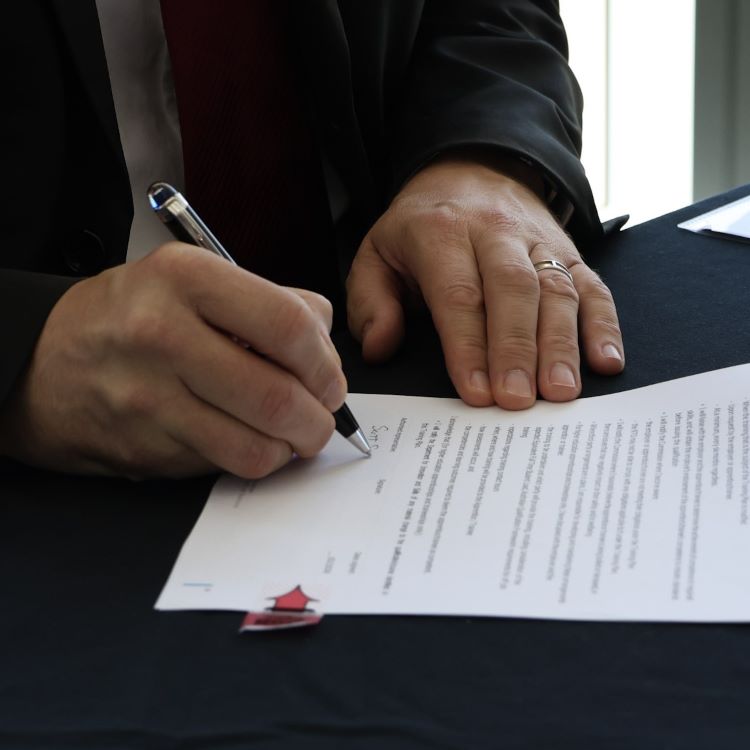 man signing a document